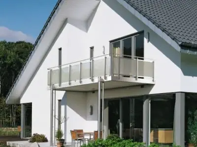Modernes Einfamilienhaus mit Balkon, großen Fenstern und gepflegtem Garten im Grünen.